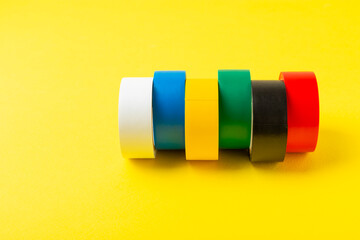 Insulating tape on a bright colored background. Set of different colors insulating tape. Reel...