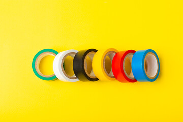Insulating tape on a bright colored background. Set of different colors insulating tape. Reel...
