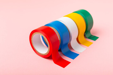 Insulating tape on a bright colored background. Set of different colors insulating tape. Reel...