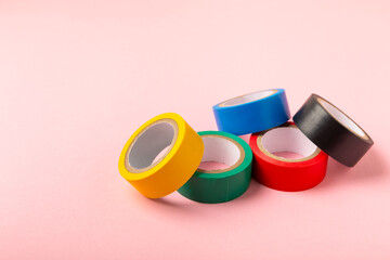 Insulating tape on a bright colored background. Set of different colors insulating tape. Reel...