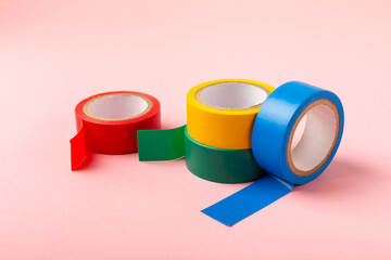 Insulating tape on a bright colored background. Set of different colors insulating tape. Reel...