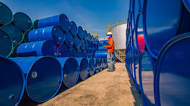 Male worker inspection record drum oil stock barrels blue horizontal - Powered by Adobe
