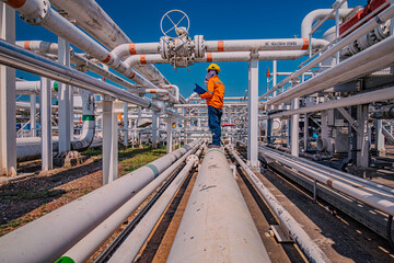 Male worker inspection at steel long pipes and pipe elbow in station oil factory during refinery...