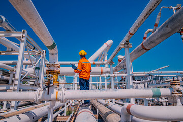 Male worker inspection at steel long pipes and pipe elbow in station oil factory during refinery...