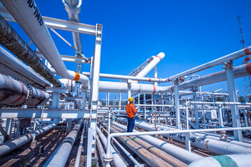 Male worker inspection at steel long pipes and pipe elbow in station oil factory during refinery...