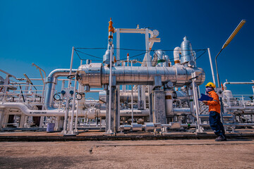 Naklejka premium Male worker inspection at steel long pipes and pipe elbow in station oil factory during refinery valve of visual check record