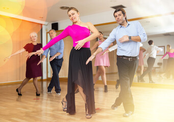 Obraz premium girl choreographer enthusiastically shows group of her students movements of modern energetic dance