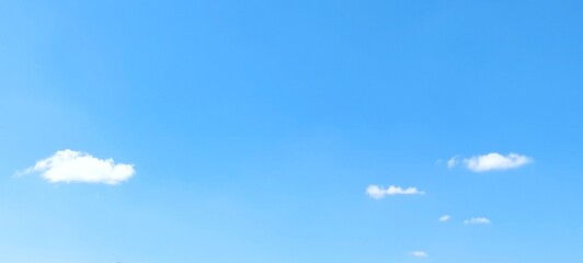 Bright sky with white fluffy clouds in summer. Blue sky with clouds. Soft white clouds float in the clear blue sky. Clear blue sky, bright spring, wallpaper landscape.