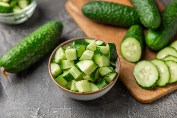 Cucumber on wooden background. Slice of cucumber on background. Fresh organic green cucumbers gherkin. Vegan. Salad ingredient. Farm vegetables. Cut vegetables with knife. Space for text. Copy space