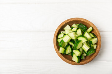Cucumber on wooden background. Slice of cucumber on background. Fresh organic green cucumbers gherkin. Vegan. Salad ingredient. Farm vegetables. Cut vegetables with knife. Space for text. Copy space