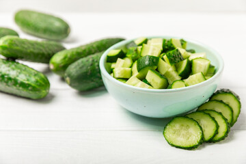 Cucumber on wooden background. Slice of cucumber on background. Fresh organic green cucumbers gherkin. Vegan. Salad ingredient. Farm vegetables. Cut vegetables with knife. Space for text. Copy space