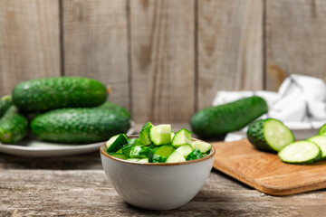 Cucumber on wooden background. Slice of cucumber on background. Fresh organic green cucumbers gherkin. Vegan. Salad ingredient. Farm vegetables. Cut vegetables with knife. Space for text. Copy space