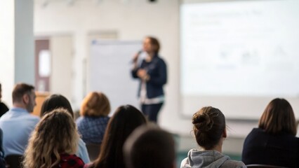 Obraz premium Speaker engaging with soft-focused audience silhouettes — connection through presentation 