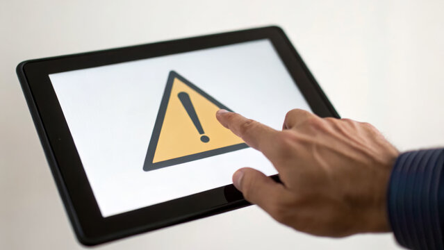 Warning sign on tablet highlights healthcare risk assessment process with focus on digital safety and alert awareness