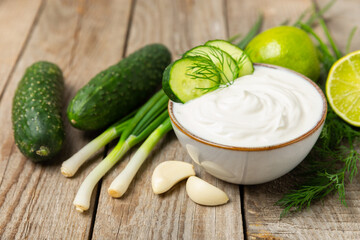 Cucumber sour cream tzatziki sauce on a wooden table.Tartar sauce. Traditional delicious appetizer....