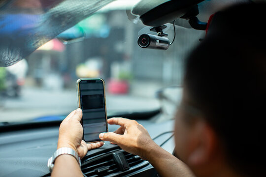 selective focus to Car CCTV camera video recorder. The technician is installing front camera car with smartphone for safety on the road.  Dashcam in car to record evidence in emergency.