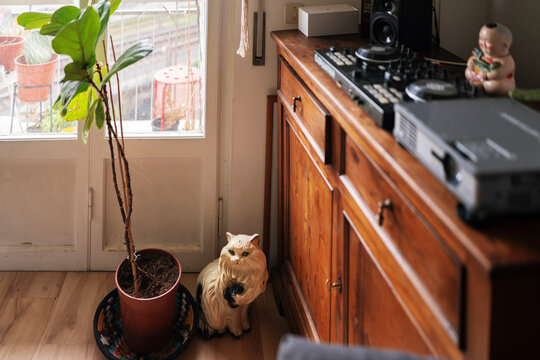 DJ mixer and audio mixer placed on wooden cabinet near window in light living room