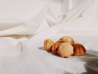 Golden Madeleine Cookies Kue Bhoi on White Fabric