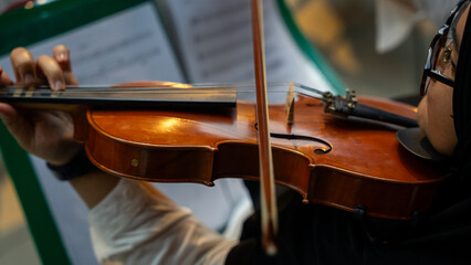 Close-Up of Violinist's Hands Playing the Violin in Orchestra Rehearsal