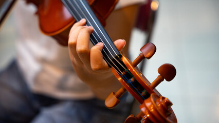 Close-Up of Violinist's Hands Playing the Violin in Orchestra Rehearsal