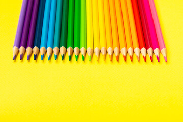 Colored pencils on a bright colored background. Equipment for coloring. Stationery for...