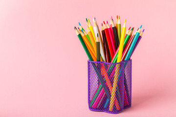 Colored pencils on a bright colored background. Equipment for coloring. Stationery for...