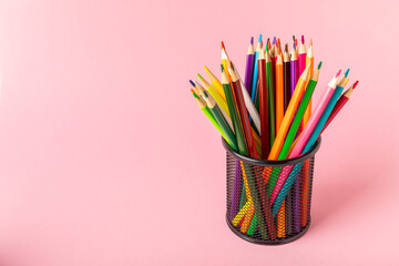 Colored pencils on a bright colored background. Equipment for coloring. Stationery for...