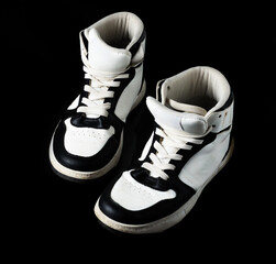 Used black and white high top sneakers with laces vintage style studio black background