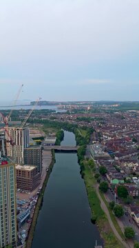 Aerial drone footage of Cardiff riverside at sunrise. Descending push-in shot flying over River Taff.