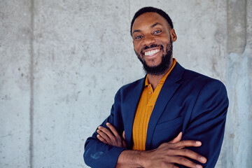 Portrait of a cheerful african american manager wearing an elegant jacket and smiling with crossed...