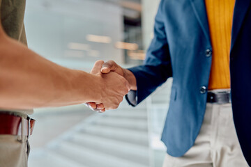 Business partners shaking hands, reaching an agreement in a bright office space, symbolizing...