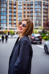 Confident woman in black blazer with lipstick