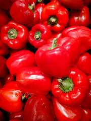 Close-up shot of an abundance of bright red bell peppers, showcasing their smooth texture and rich hue. Excellent for food blogs, culinary promotions, healthy lifestyle content, and grocery advertisem