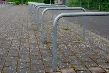 Empty bicycle racks stand waiting on cobblestone pavement