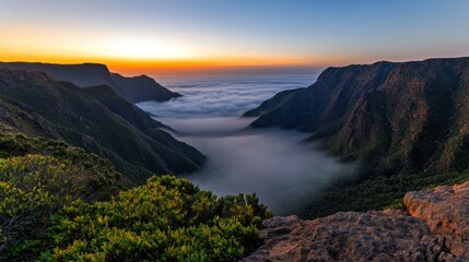 Breathtaking sunrise over mountain range with valley filled with dreamy fog