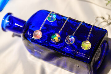 Colorful Resin Pendants on a Blue Glass Bottle