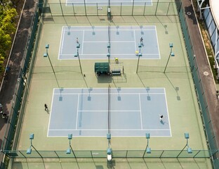 Naklejka premium Aerial view of tennis courts with players in action.