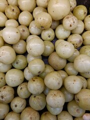 Fresh green fruits collected from local farms displayed in a market setting during a sunny afternoon