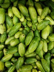Fresh green cucumbers gathered and displayed at a local market during the summer season in a vibrant and bustling community