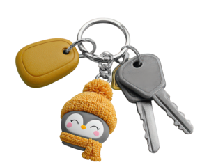 Penguin keychain with yellow scarf and beanie, attached to silver keys and yellow key fob, cute and cheerful accessory for winter or holiday season