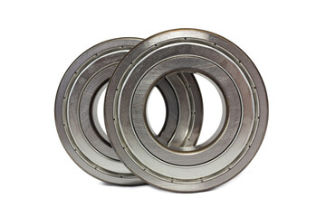 Two shiny metal ball bearings are isolated on a crisp white background.