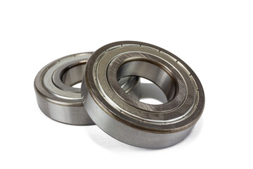 Two shiny metal ball bearings are isolated on a crisp white background.