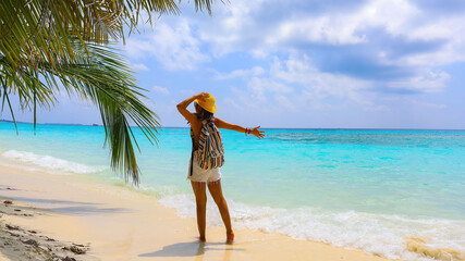 Back view of a woman with a backpack on the ocean nature in summer holiday
