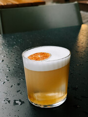 Refreshing cocktail with a citrus garnish served on a rainy day at a downtown bar