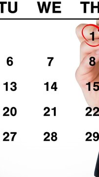 Animation of hand drawing red ring over january 1st on a monthly calendar