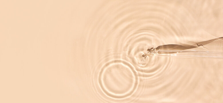 pipette serum in water on beige background ripples water drops natural sunlight