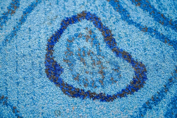 Detailed close-up of a textured, handcrafted rug featuring shades of blue. The intricate design...
