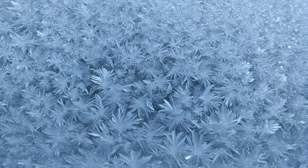 Fototapeta premium Stunning close up shot of frost forming intricate patterns on a cold winter windowpane, showcasing nature's delicate artistry in freezing temperatures.