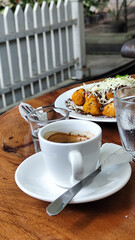 Serve various snacks and drinks on a warm wooden table, in an outdoor cafe. with natural blur.