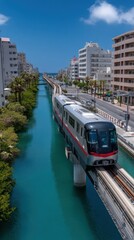 Modern cityscape with elevated train running along waterway surrounded by contemporary high-rise buildings on a sunny day